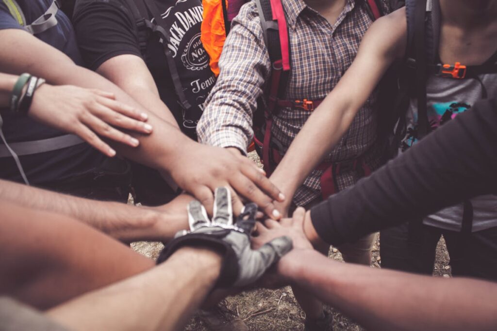 Group of training partners with hands together showing team accountability in fitness